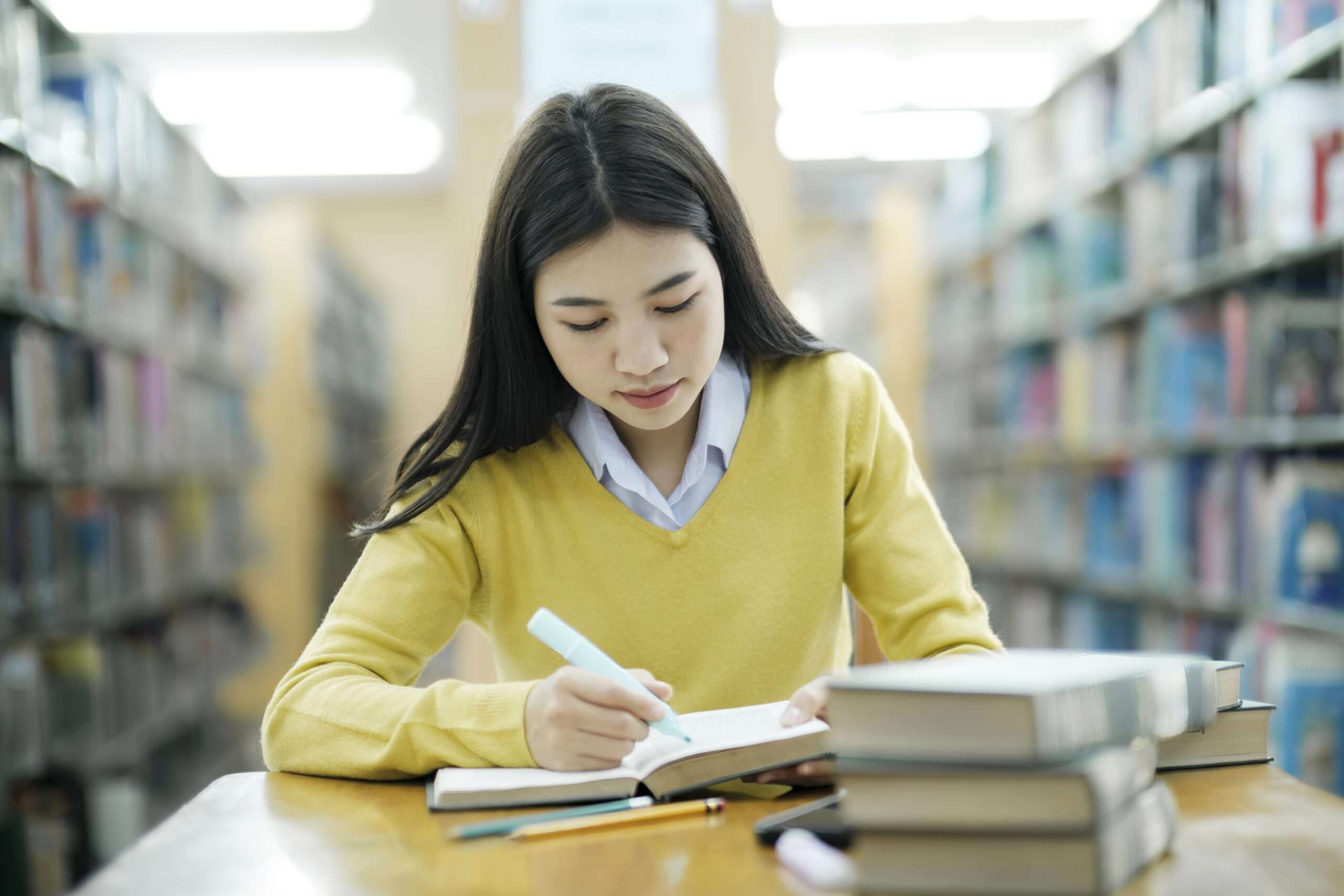 Um estudante focado na prova DELF, rodeado por livros avançados de francês e recursos multimídia, simbolizando a jornada para aprofundar o conhecimento na língua.